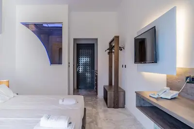 a white room with a bed and a telephone at Bright Star in Faliraki
