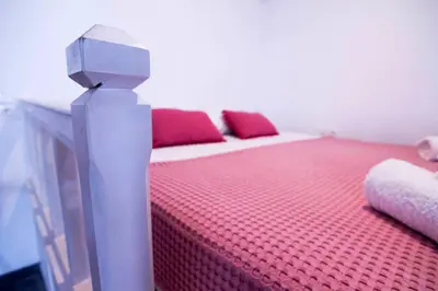 a room with two beds with red pillows at Aegli Apartments in Symi