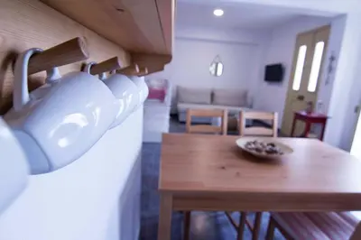 a kitchen and living room with a table and a couch at Aegli Apartments in Symi