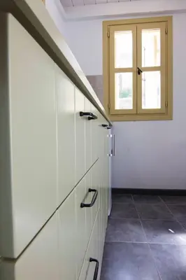 a room with white cabinets and a window at Aegli Apartments in Symi