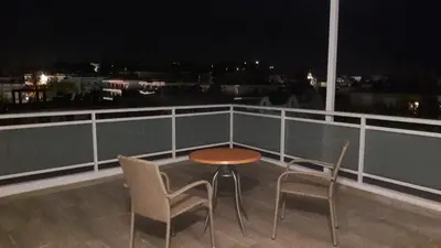 a table and two chairs on a balcony at night at International Hotel in Rhodes Town