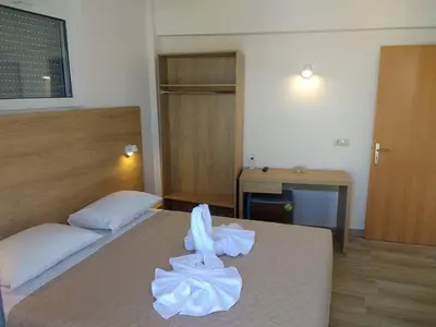 a hotel room with two beds and a desk at International Hotel in Rhodes Town