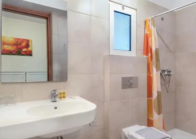 a bathroom with a sink and a mirror at International Hotel in Rhodes Town