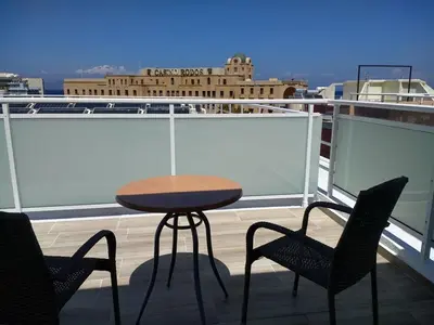 a table and chairs on top of a balcony at International Hotel in Rhodes Town