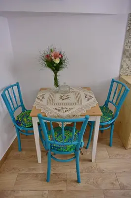 a table with two chairs and a vase with flowers on it at Villa Mariza 1920 in Rhodes Town