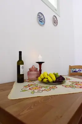 a table with a bottle of wine and a plate of bananas at Villa Mariza 1920 in Rhodes Town