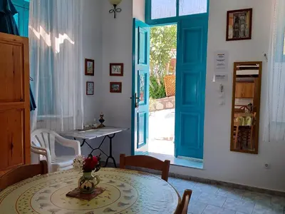 a dining room with a table and a blue door at Halki Townhouse in Halki
