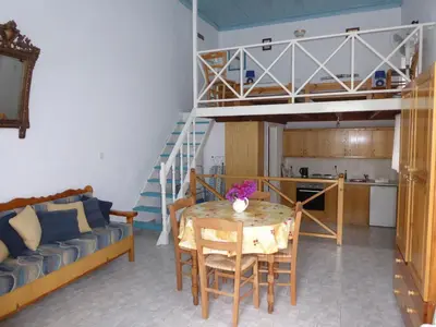 a living room with a table and a bunk bed at Halki Townhouse in Halki