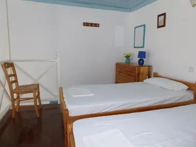 a bedroom with two beds and a chair at Halki Townhouse in Halki