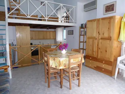 a dining room with a table and a loft bed at Halki Townhouse in Halki