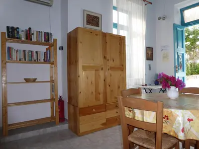a dining room with a table and a wooden cabinet at Halki Townhouse in Halki