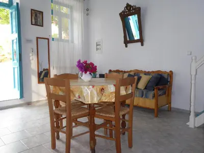 a dining room with a table and chairs and a couch at Halki Townhouse in Halki
