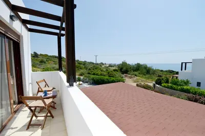 a balcony with two chairs and a view of the ocean at Villa Nastazia in Kiotari