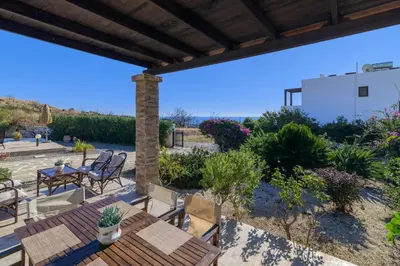 a patio with a table and chairs and plants at Villa Nastazia in Kiotari