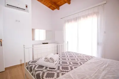 a bedroom with a bed with two towels on it at Emerald Dream Apartment in Faliraki