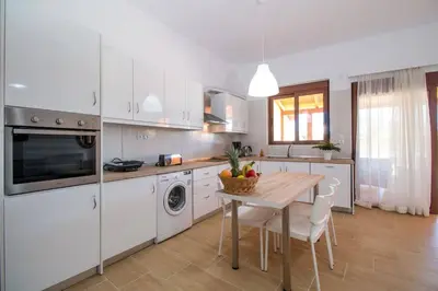a kitchen with a table and a dining room at Emerald Dream Apartment in Faliraki
