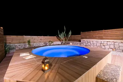 a large blue pool in the middle of a patio at Emerald Dream Apartment in Faliraki