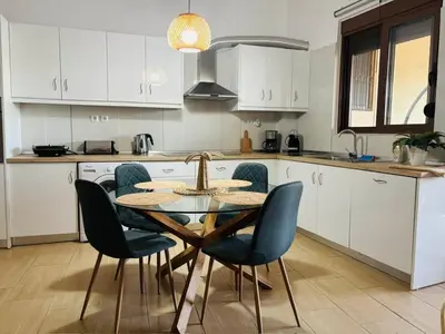 a kitchen with a table and chairs in a kitchen at Emerald Dream Apartment in Faliraki