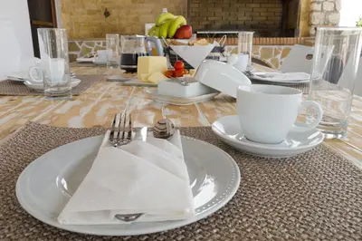 a table with white plates and cups and napkins at Villa Dimitra Gennadi in Gennadi