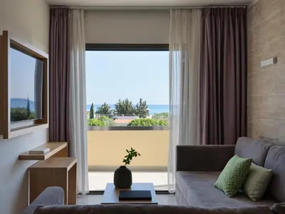 a living room with a couch and a large window at Atlantica Mikri Poli Rhodes in Kolimbia