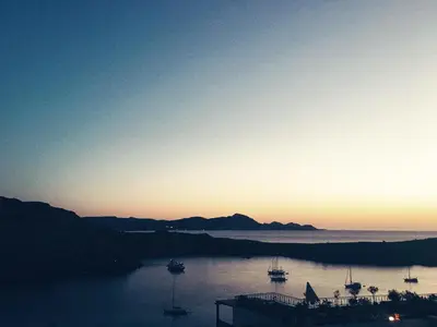 a sunset over a body of water with boats in it at Villa Vasilia in Líndos