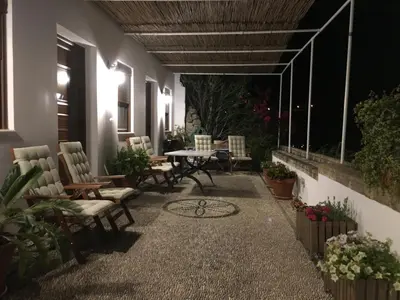 a patio at night with chairs and a table at Villa Vasilia in Líndos