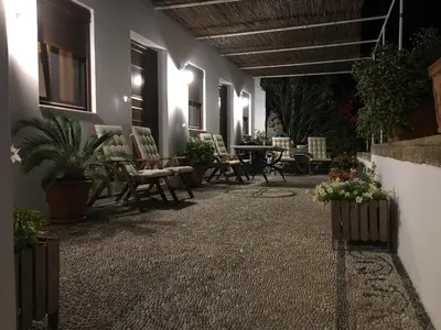 a patio with chairs and a table and plants at Villa Vasilia in Líndos