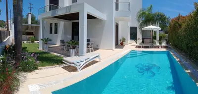 a villa with a swimming pool in front of a house at Villa Anastasia in Psinthos