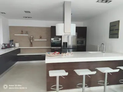a kitchen with a white counter and stools in it at Villa Anastasia in Psinthos