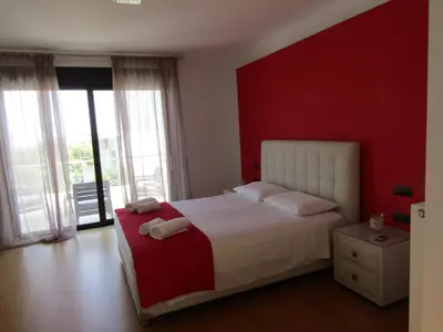 a bedroom with a bed with a red wall at Villa Anastasia in Psinthos