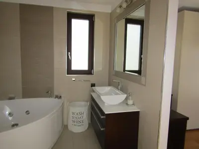 a bathroom with a tub and a sink and a mirror at Villa Anastasia in Psinthos