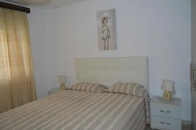 a bedroom with a bed with two night stands and two lamps at Anthi City Center Apartment in Rhodes Town