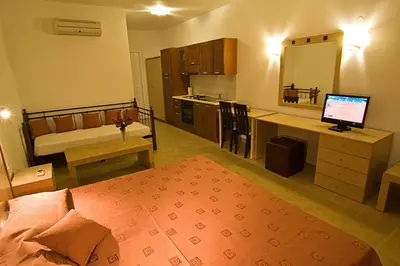 a bedroom with a bed and a desk with a computer at Sifis Studios Pefkos in Pefki Rhodes