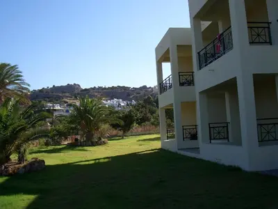 a view of a building with palm trees next to it at Sifis Studios Pefkos in Pefki Rhodes