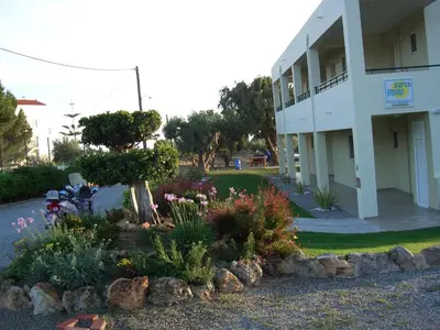a garden in front of a building with flowers at Sifis Studios Pefkos in Pefki Rhodes