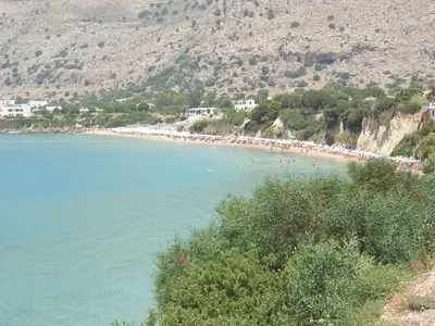 a beach with a bunch of people in the water at Sifis Studios Pefkos in Pefki Rhodes