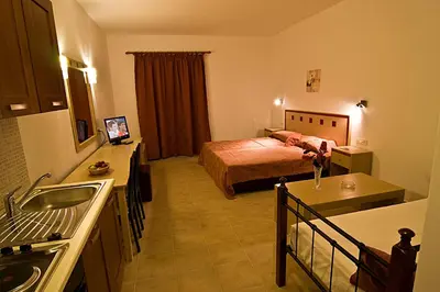 a hotel room with a bed and a kitchen at Sifis Studios Pefkos in Pefki Rhodes