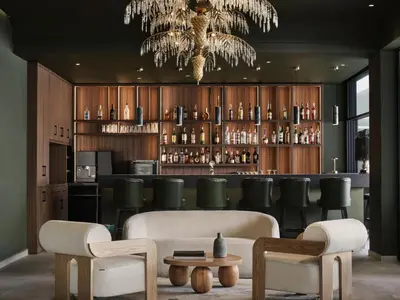 a bar with green chairs and a chandelier at Pearl Hotel in Rhodes Town
