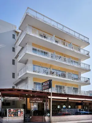 a tall white building with balconies on it at Pearl Hotel in Rhodes Town