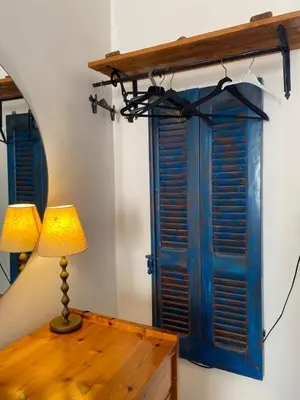 a table with a lamp next to a blue window at Florida Hotel & Apartments - Adults Only in Rhodes Town