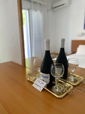 two bottles of wine and two glasses on a table at Florida Hotel & Apartments - Adults Only in Rhodes Town