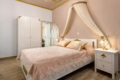 a bedroom with a bed and a dresser and a mirror at Marika's Deluxe Rooms in Symi