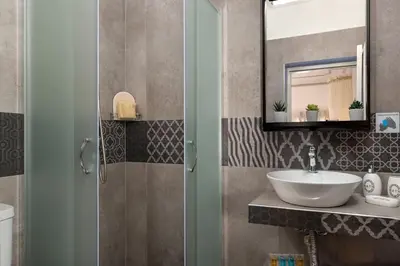 a bathroom with a sink and a mirror at Marika's Deluxe Rooms in Symi