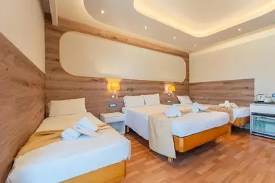 a hotel room with two beds and a mirror at Arte Hotel in Rhodes Town