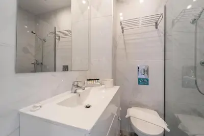 a white bathroom with a sink and a toilet at Arte Hotel in Rhodes Town