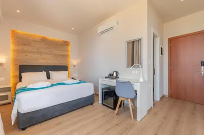 a bedroom with a bed and a desk and a chair at Arte Hotel in Rhodes Town