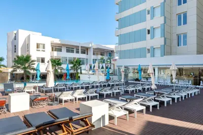 a group of lounge chairs and umbrellas in front of a building at Arte Hotel in Rhodes Town
