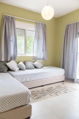 a bedroom with two beds and a window at New Town Apartments in Rhodes Town