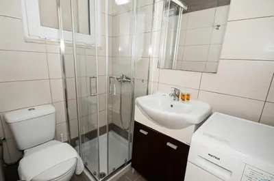 a bathroom with a toilet and a sink and a shower at New Town Apartments in Rhodes Town