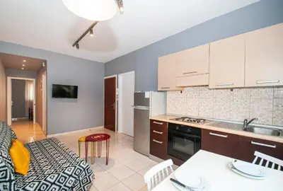 a kitchen and living room with a table and chairs at New Town Apartments in Rhodes Town